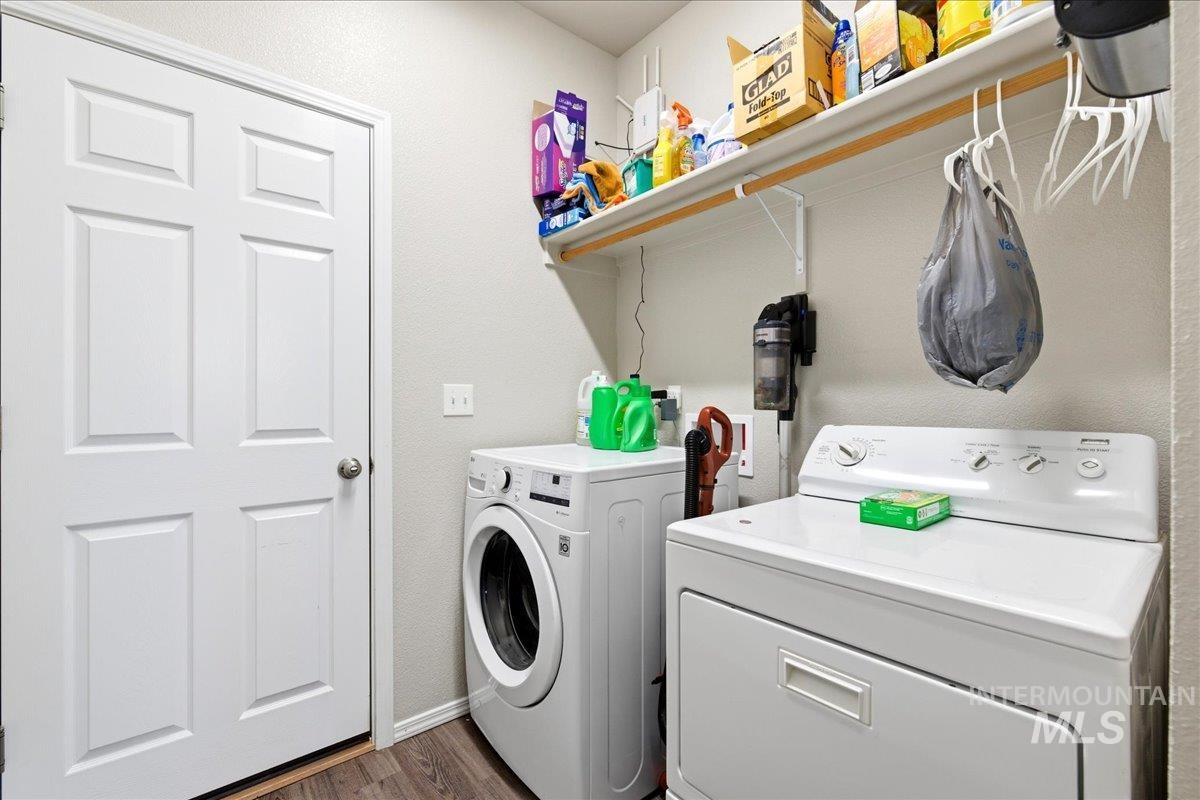 843 Southwest Levant Way Mountain Home, ID 83647 - Photo 23 of 45 Laundry area with washer and dryer, dark wood finished floors, and a textured wall