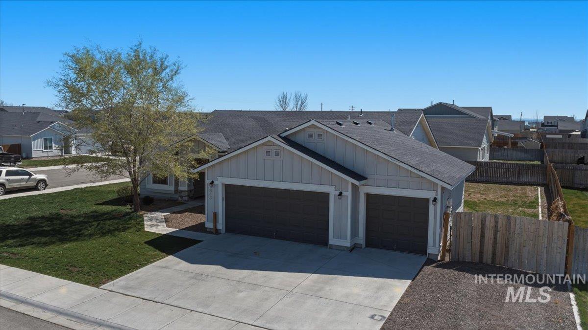 843 Southwest Levant Way Mountain Home, ID 83647 - Photo 27 of 45 View of front of property with board and batten siding, a garage, concrete driveway, and a residential view