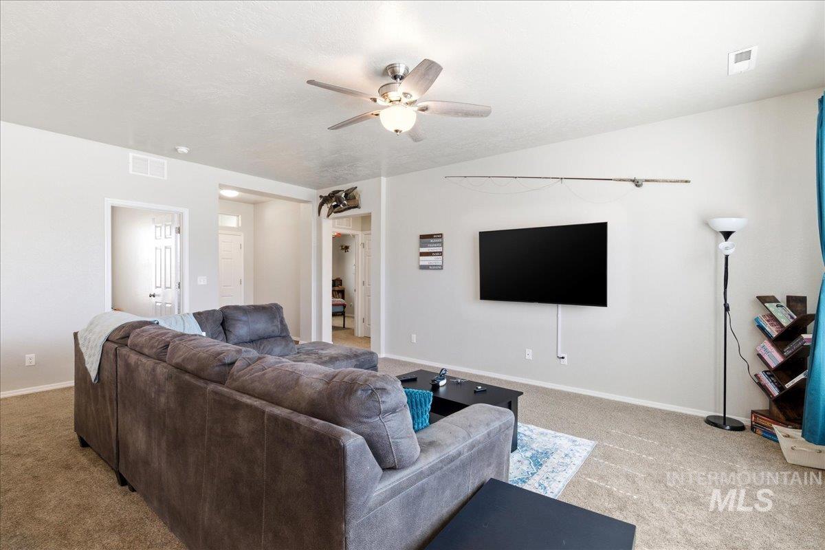 843 Southwest Levant Way Mountain Home, ID 83647 - Photo 6 of 45 Living area with ceiling fan and light carpet