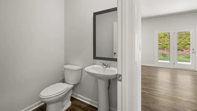 a bathroom with a toilet sink and mirror