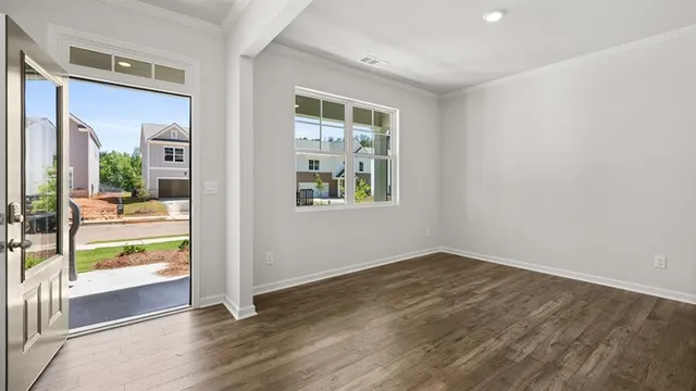 an empty room with wooden floor and windows