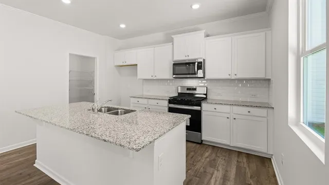 a kitchen with granite countertop a sink stove and refrigerator