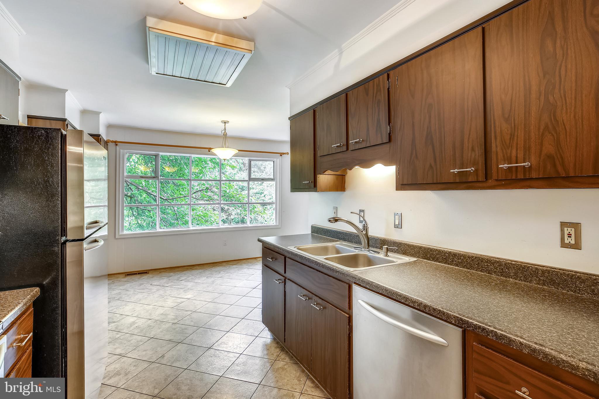 9505 Emory Grove Road Gaithersburg, MD 20877 - Photo 23 of 75 a kitchen with a sink a stove cabinets and a refrigerator
