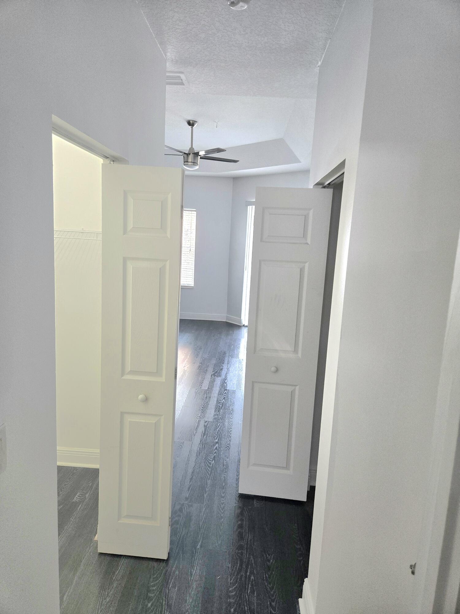 2472 Southwest Valnera Street Port St. Lucie, FL 34953 - Photo 16 of 30 an empty room with wooden floor and a ceiling fan