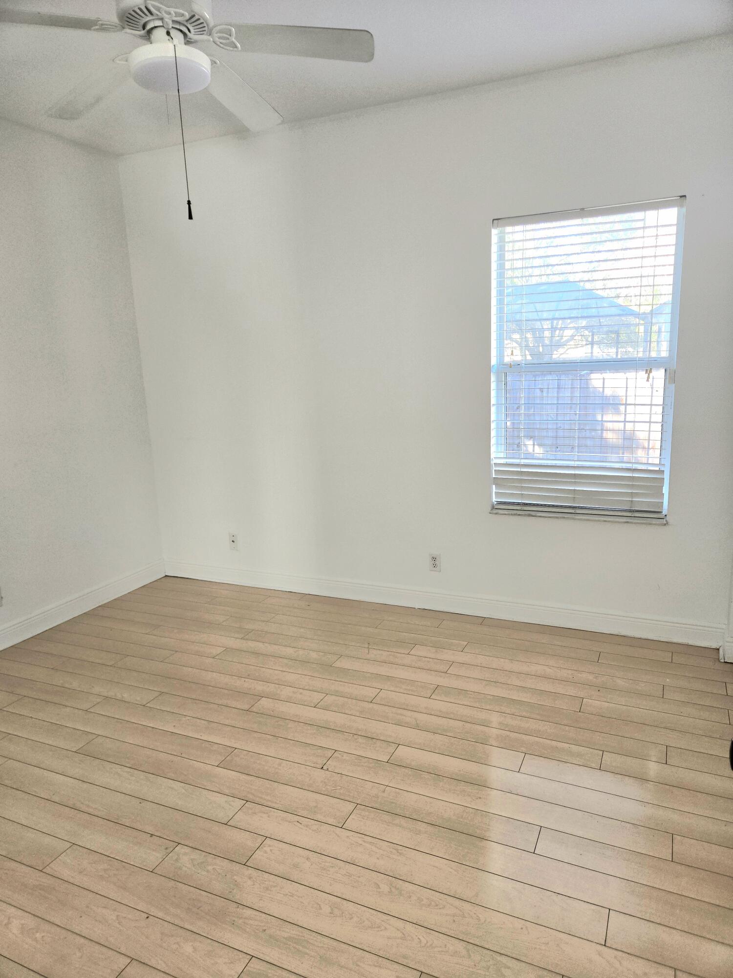 2472 Southwest Valnera Street Port St. Lucie, FL 34953 - Photo 21 of 30 a view of an empty room with wooden floor and a window