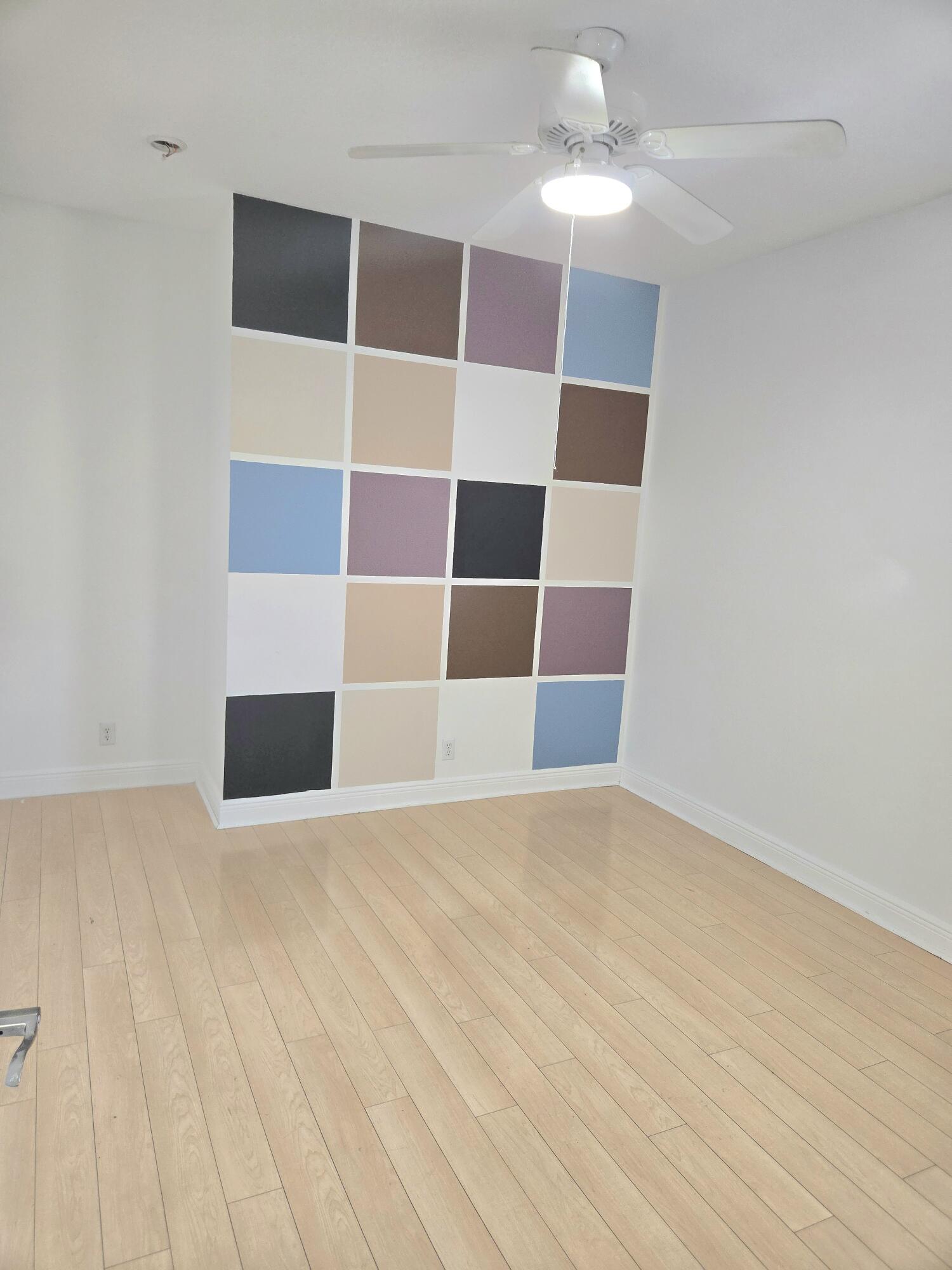 2472 Southwest Valnera Street Port St. Lucie, FL 34953 - Photo 22 of 30 a view of a room with wooden floor and a ceiling fan