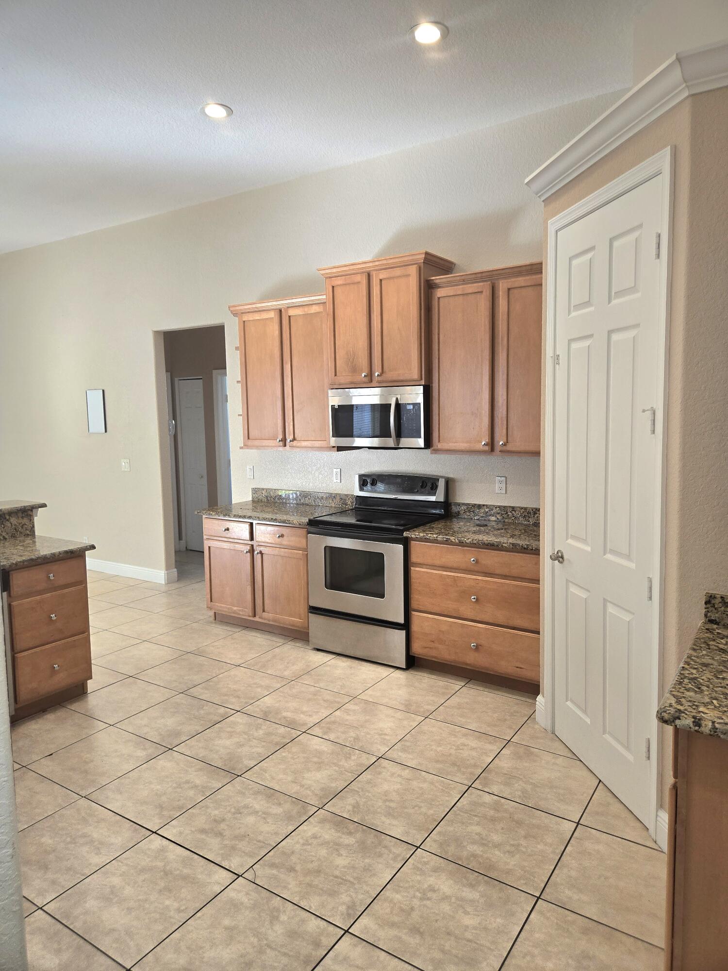2472 Southwest Valnera Street Port St. Lucie, FL 34953 - Photo 8 of 30 a kitchen with stainless steel appliances a stove a sink and a microwave