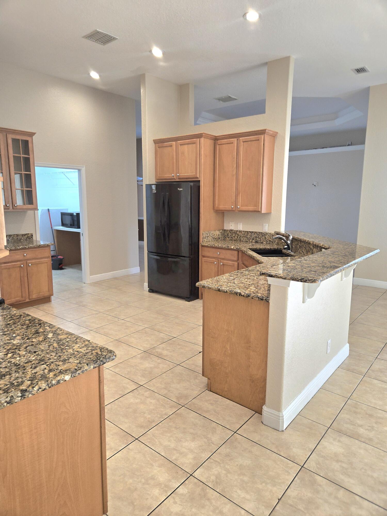 2472 Southwest Valnera Street Port St. Lucie, FL 34953 - Photo 9 of 30 a kitchen with stainless steel appliances granite countertop a stove a sink and a refrigerator