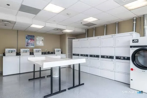 a kitchen with a sink a stove cabinets and chairs