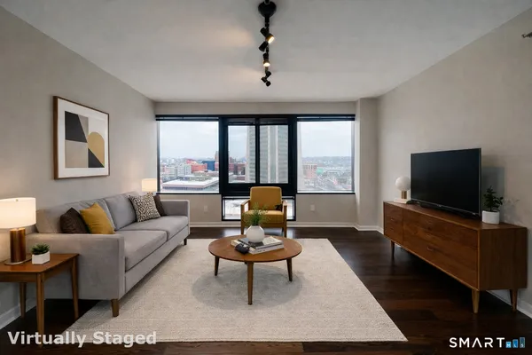 a living room with furniture a window and a flat screen tv