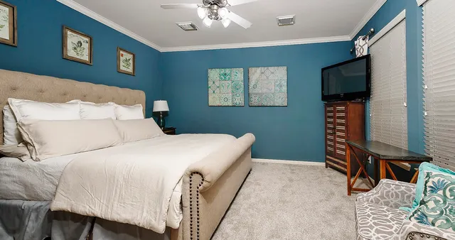 a bedroom with a bed and a flat screen tv