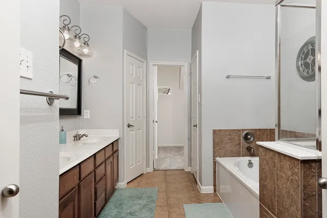 a spacious bathroom with a double vanity sink and a mirror