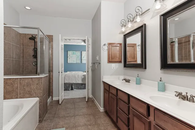 a spacious bathroom with a double vanity sink mirror and bathtub