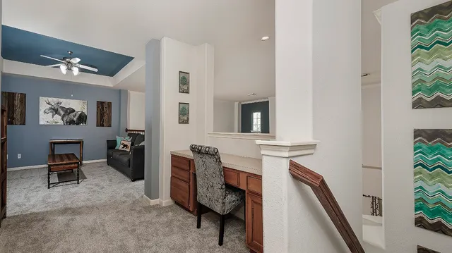 a view of a hallway with workspace and windows