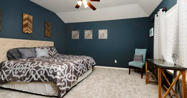 a bedroom with a bed and painting on the wall