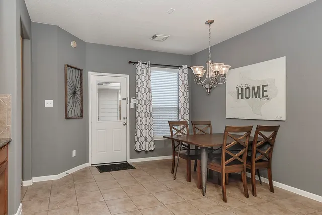 a view of a dining room with furniture and chandelier
