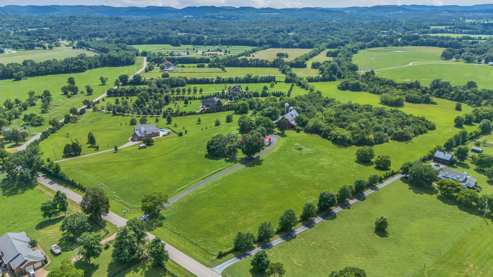 4125 Trinity Road Franklin, TN 37067 - Photo 2 of 44 an aerial view of green landscape with trees houses and mountain view