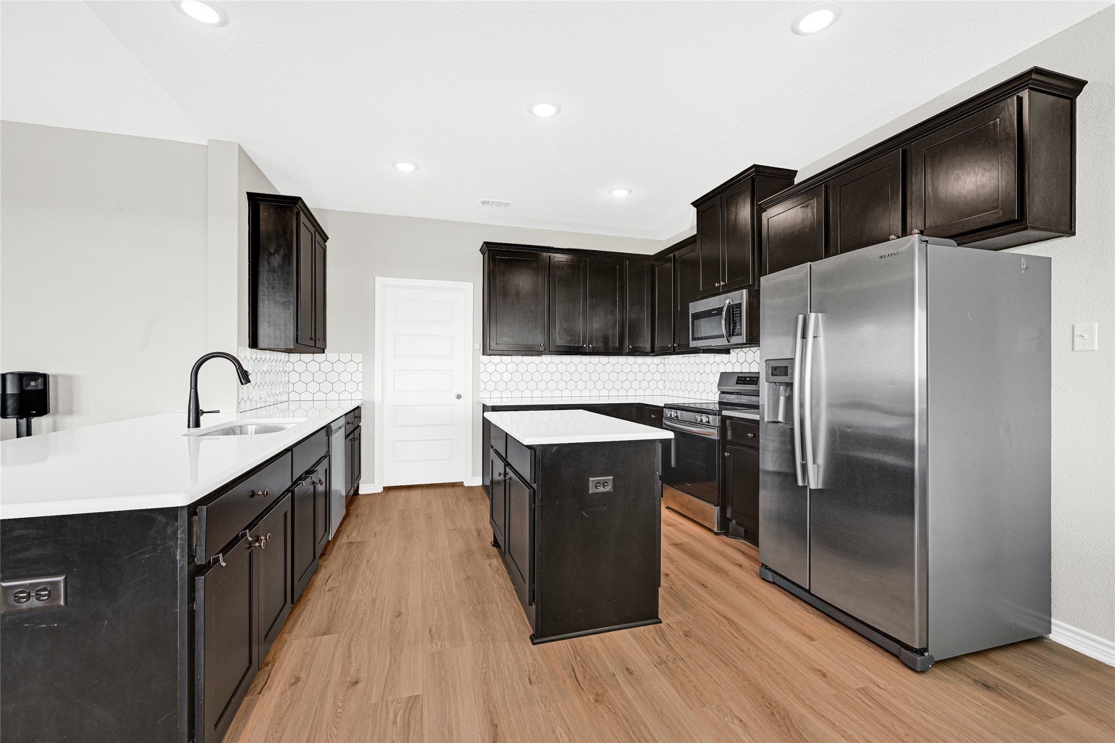 2256 West Bayshore Road Anahuac, TX 77514 - Photo 19 of 34 a kitchen with stainless steel appliances granite countertop a sink a stove and a refrigerator