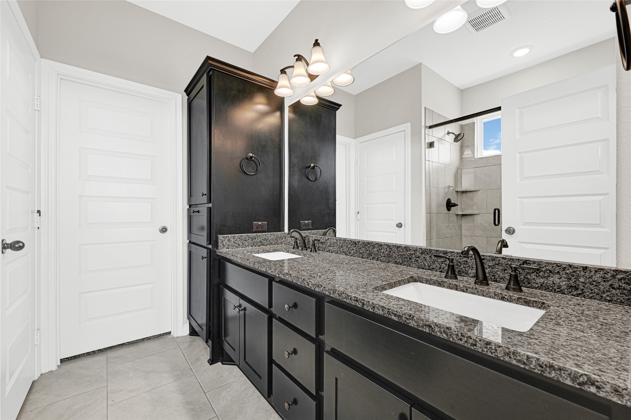 2256 West Bayshore Road Anahuac, TX 77514 - Photo 23 of 34 a bathroom with a granite countertop double vanity sink a large mirror and a shower