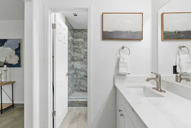 a en suite bathroom with a sink a mirror and shower