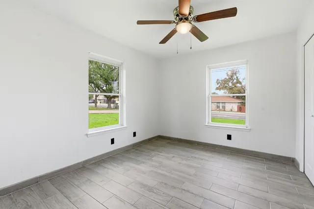 a view of room with window ceiling fan and hardwood floor