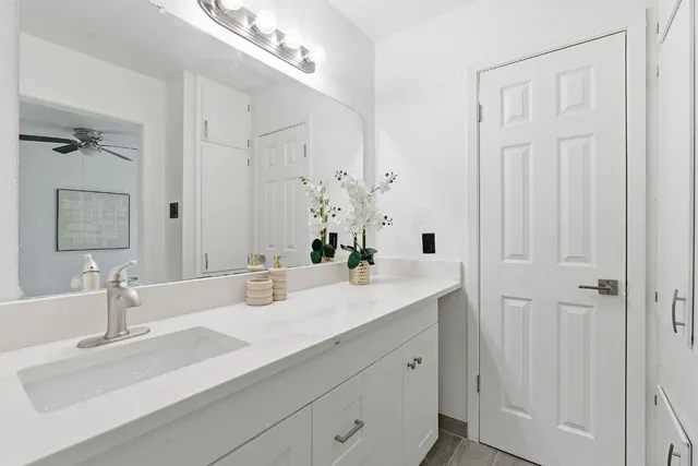 a bathroom with double vanity sinks and a mirror