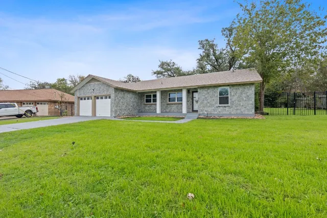 a front view of a house with a yard and trees