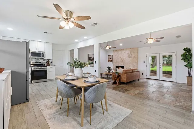 a living room with furniture kitchen view and a chandelier