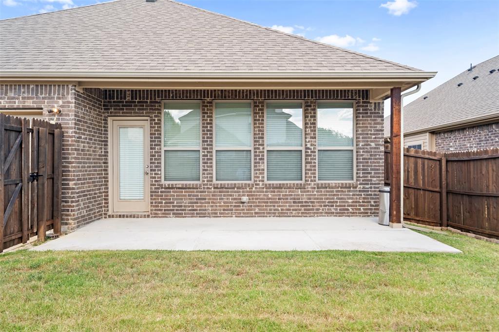 119 Happy Lane Red Oak, TX 75154 - Photo 35 of 37 Covered patio area featuring a concrete slab, brick exterior, and a wood-paneled fence