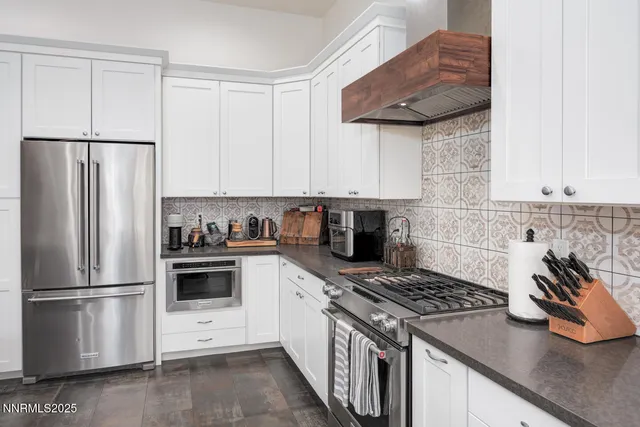 a kitchen with stainless steel appliances white cabinets and a stove top oven
