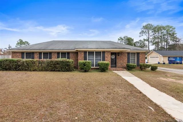 a front view of a house with a yard and potted plants