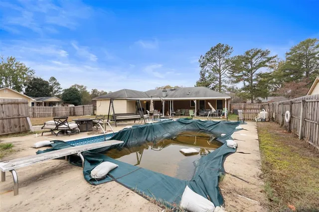 a view of a house with swimming pool and sitting area