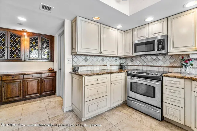 a kitchen with stainless steel appliances granite countertop a stove a sink and a microwave