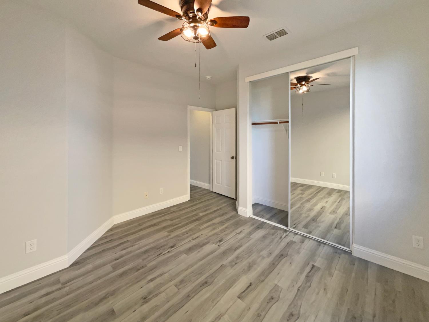4087 Preserve Way Rancho Cordova, CA 95742 - Photo 17 of 24 an empty room with wooden floor closet and windows