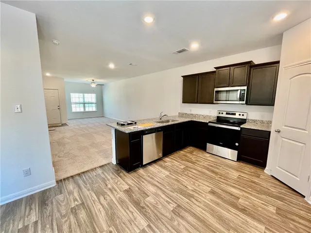 a kitchen with stainless steel appliances granite countertop a stove a sink and a refrigerator