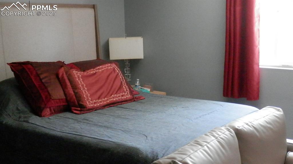 4450 Chaparral Road Colorado Springs, CO 80917 - Photo 15 of 29 a bedroom with a bed and a lamp