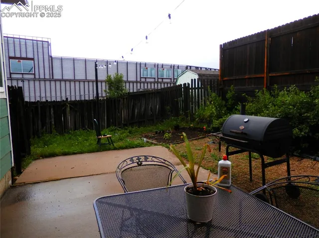 a backyard of a house with table and chairs