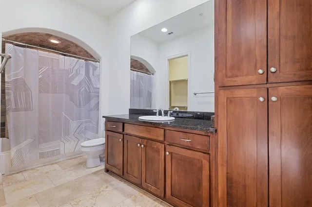 a bathroom with a granite countertop sink toilet and shower