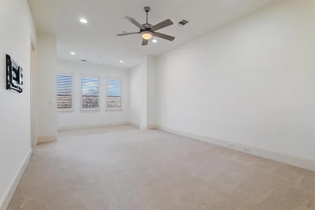 en empty room with windows and ceiling fan