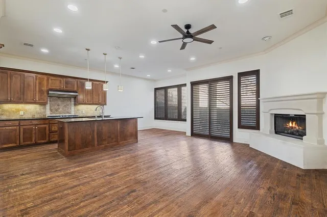 a view of kitchen with granite countertop stainless steel appliances and wooden floor