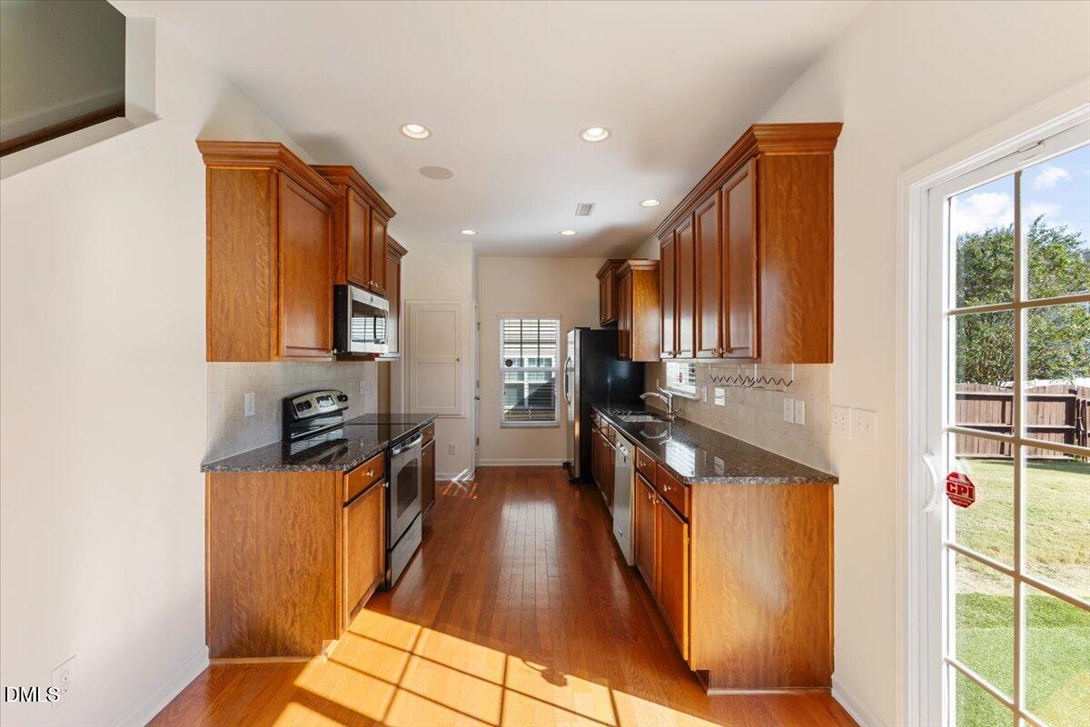 4440 Cardinal Grove Boulevard Raleigh, NC 27616 - Photo 8 of 42 a kitchen with stainless steel appliances granite countertop a refrigerator a stove top oven a sink and dishwasher