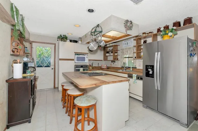 a kitchen with stainless steel appliances granite countertop a sink and a refrigerator