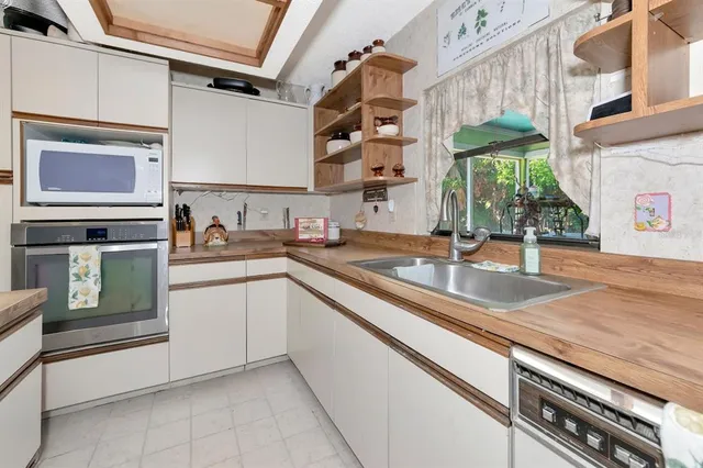 a kitchen with stainless steel appliances granite countertop a refrigerator a stove and a sink