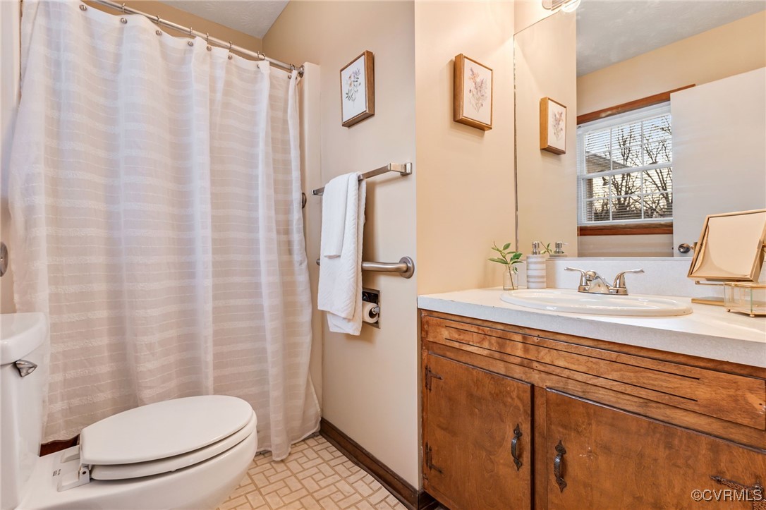 8087 Bell Road Dillwyn, VA 23936 - Photo 19 of 37 a bathroom with a sink a toilet and shower curtain