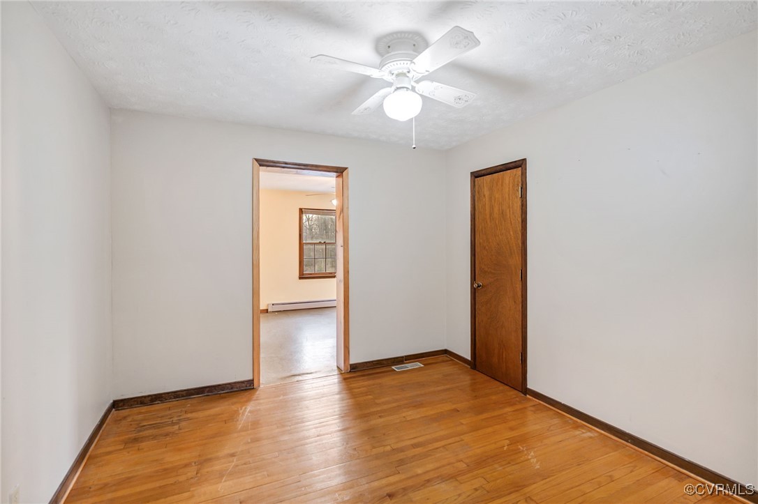 8087 Bell Road Dillwyn, VA 23936 - Photo 25 of 37 an empty room with wooden floor and a ceiling fan