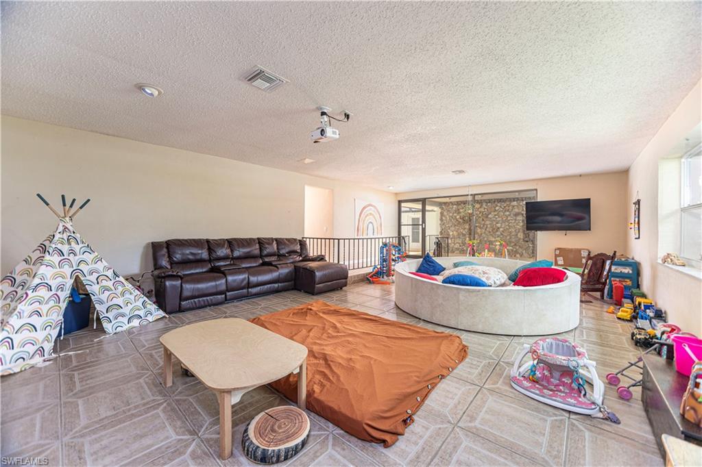 339 Delaware Road Lehigh Acres, FL 33936 - Photo 13 of 30 a living room with furniture and a fireplace