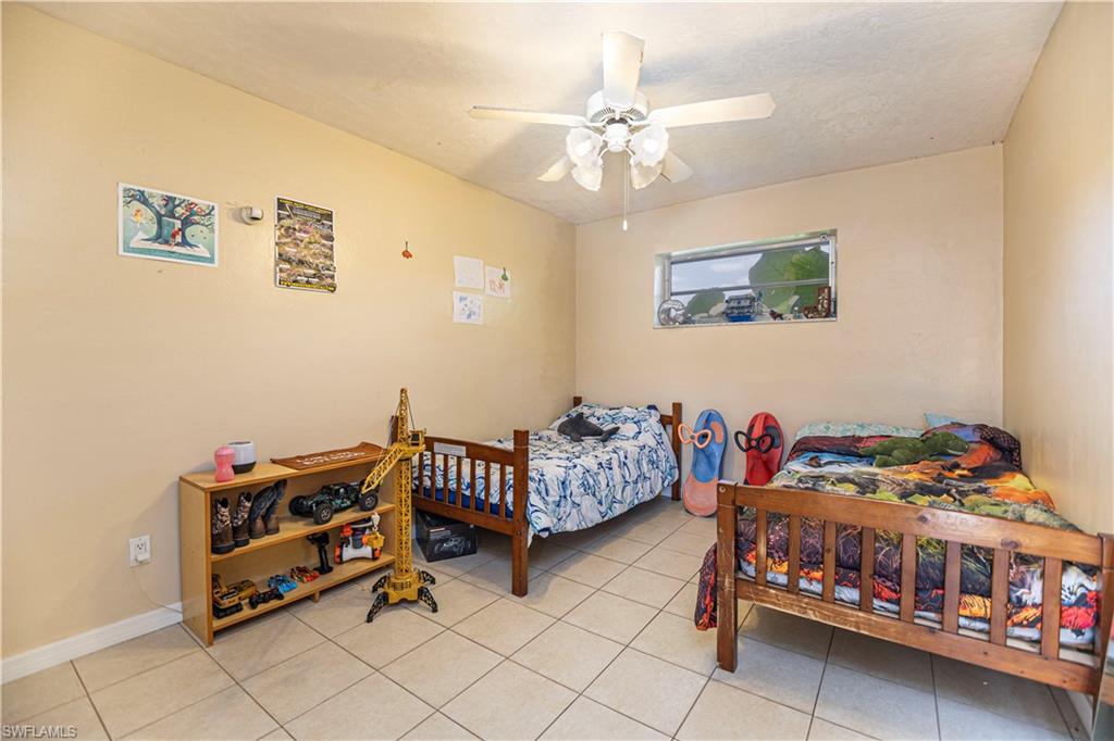 339 Delaware Road Lehigh Acres, FL 33936 - Photo 15 of 30 a bedroom with furniture and a chandelier