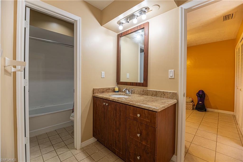 339 Delaware Road Lehigh Acres, FL 33936 - Photo 16 of 30 a bathroom with a granite countertop sink and a mirror