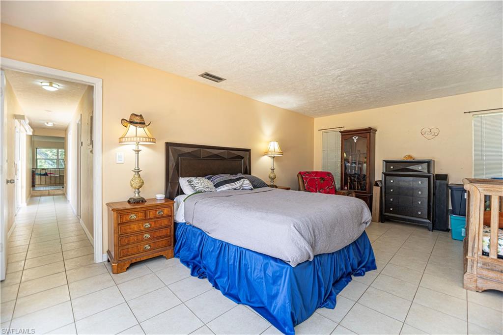 339 Delaware Road Lehigh Acres, FL 33936 - Photo 18 of 30 a spacious bedroom with a bed and a dresser