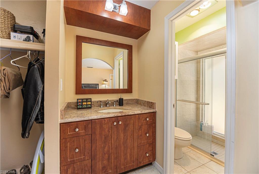 339 Delaware Road Lehigh Acres, FL 33936 - Photo 20 of 30 a bathroom with a toilet sink vanity and mirror